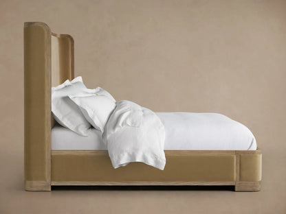Darien Curved Shelter Bed with low footboard, oak veneer frame, upholstered panels, and white bedding on a beige background.