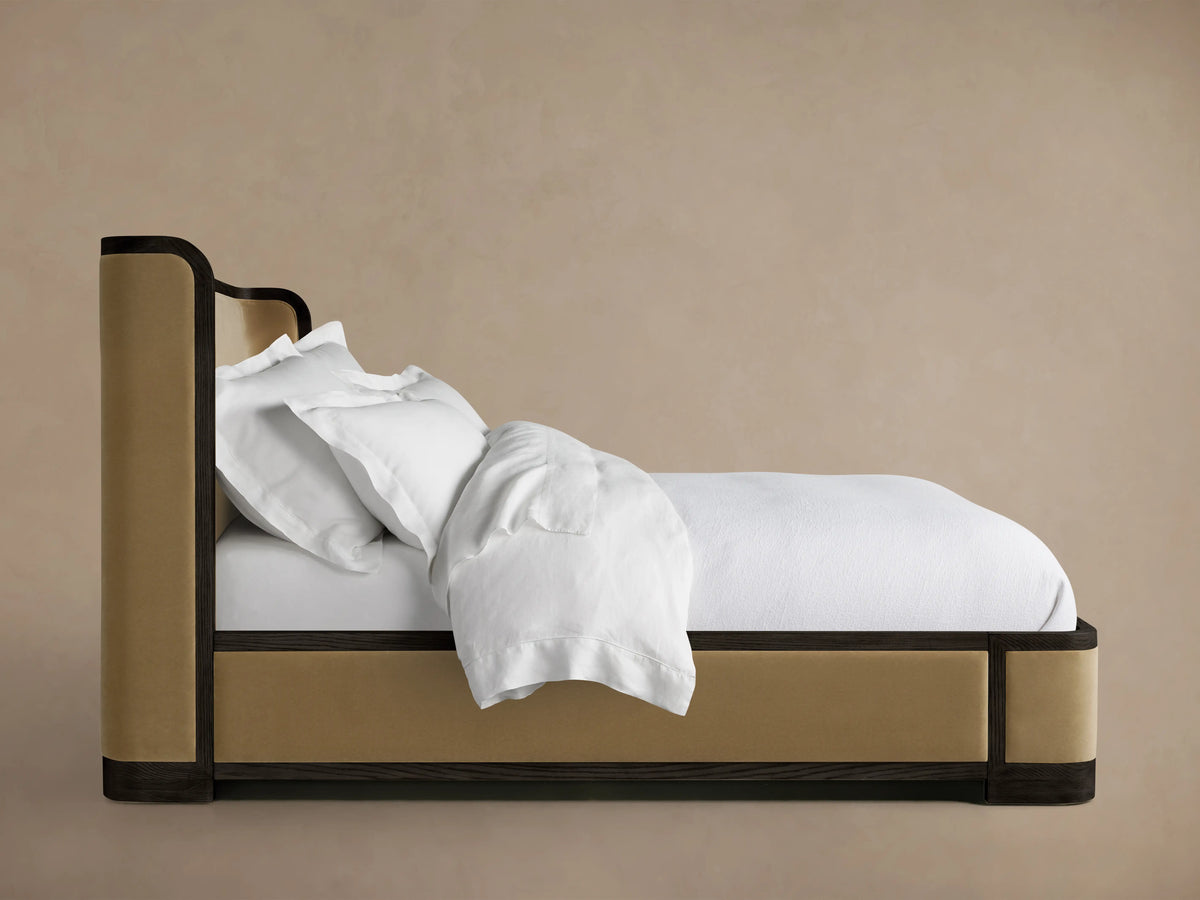 Curved headboard of the Darien Shelter Bed made from oak veneer, featuring dark wood accents and upholstered beige panel.