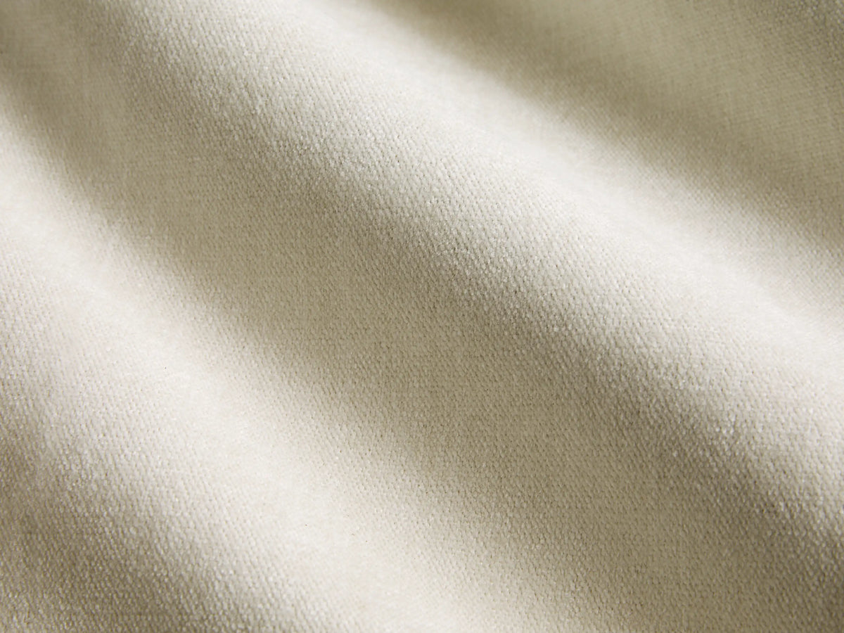 Darien Curved Shelter Bed, side view. Cream upholstered panels within a dark wood frame, made with white bedding.