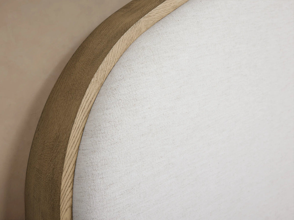 Danny Bed with light oak frame, arched white fabric headboard, ribbed white bedding, and a grey throw blanket.