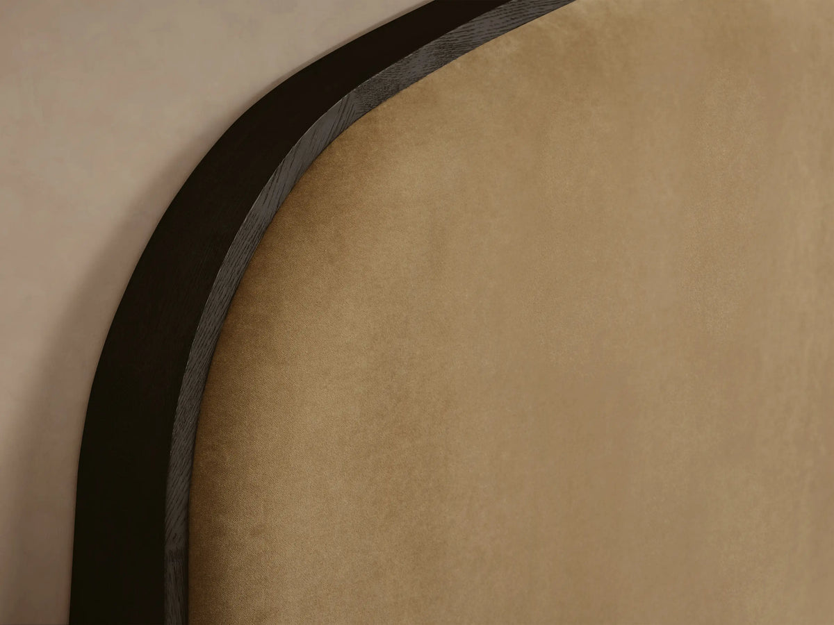 Danny Bed with dark wood frame, arched tan upholstered headboard, white ribbed bedding, two pillows, and beige throw.