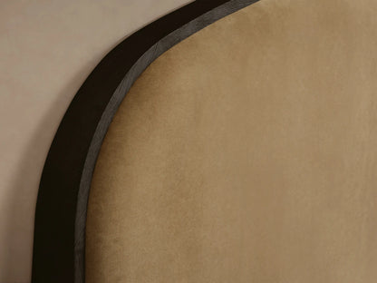 Danny Bed with arched tan upholstered headboard outlined in dark wood, dark wood frame, and white ridged bedding with beige throw.