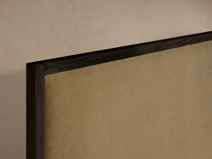 Darien Panel Bed with High Footboard showing a close-up of the wood frame and upholstered panel, in a neutral setting.