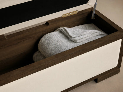 Front-side view of Darien Storage Bench with dark stained oak wood frame and light cream upholstered top and front panel.