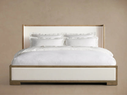 Darien Shelter Bed with Low Footboard in solid oak, featuring a tall upholstered headboard and white bedding, displayed against a neutral background.
