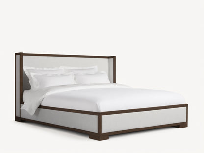 Front view of the Darien Shelter Bed with a dark brown wood frame and light-colored upholstered panels, dressed with white bedding.