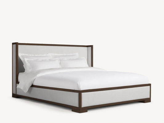 Front view of the Darien Shelter Bed with a dark brown wood frame and light-colored upholstered panels, dressed with white bedding.