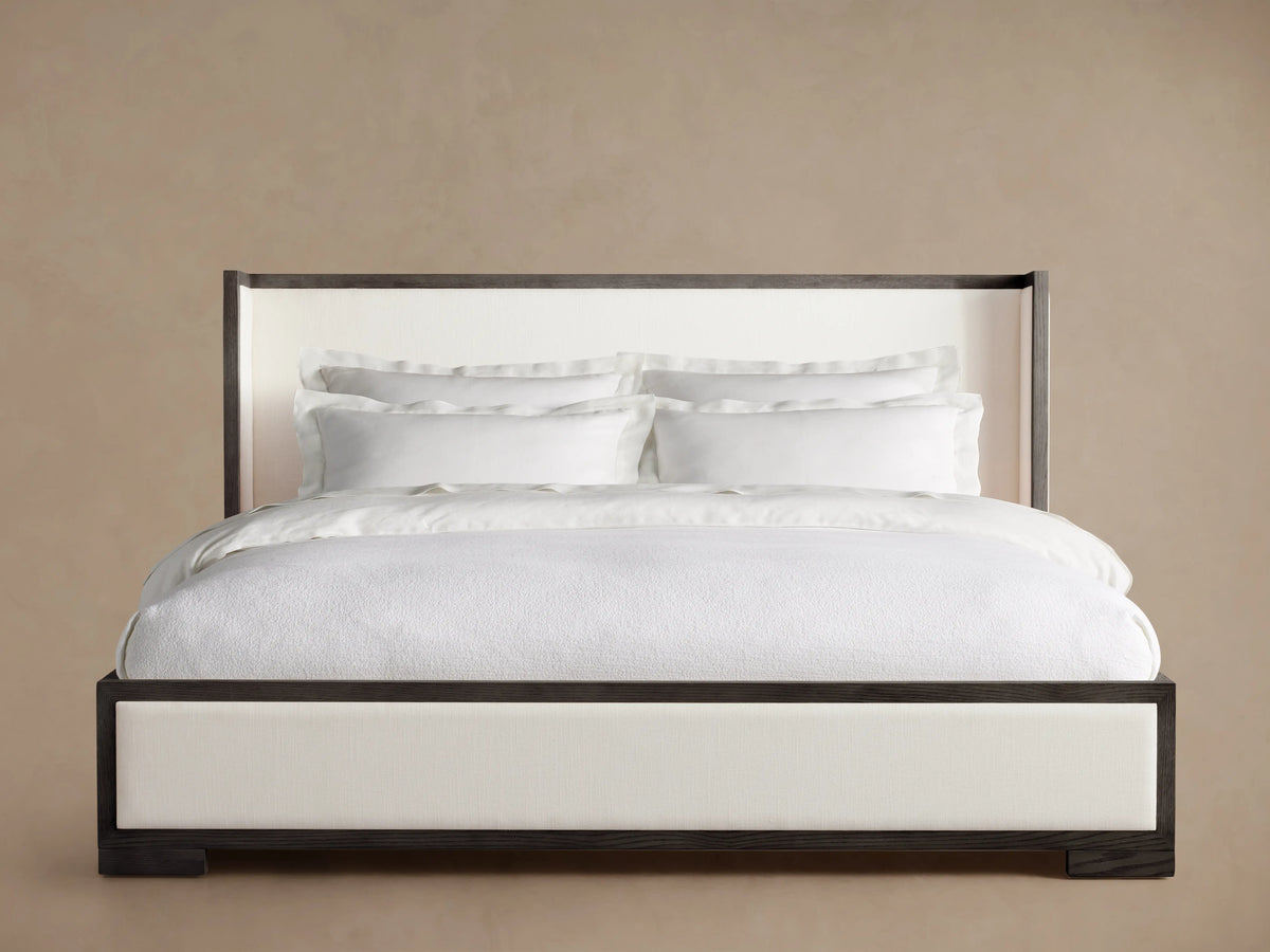 Darien Shelter Bed featuring a low footboard, light upholstered panels, contrasting oak frame, and crisp white bedding.