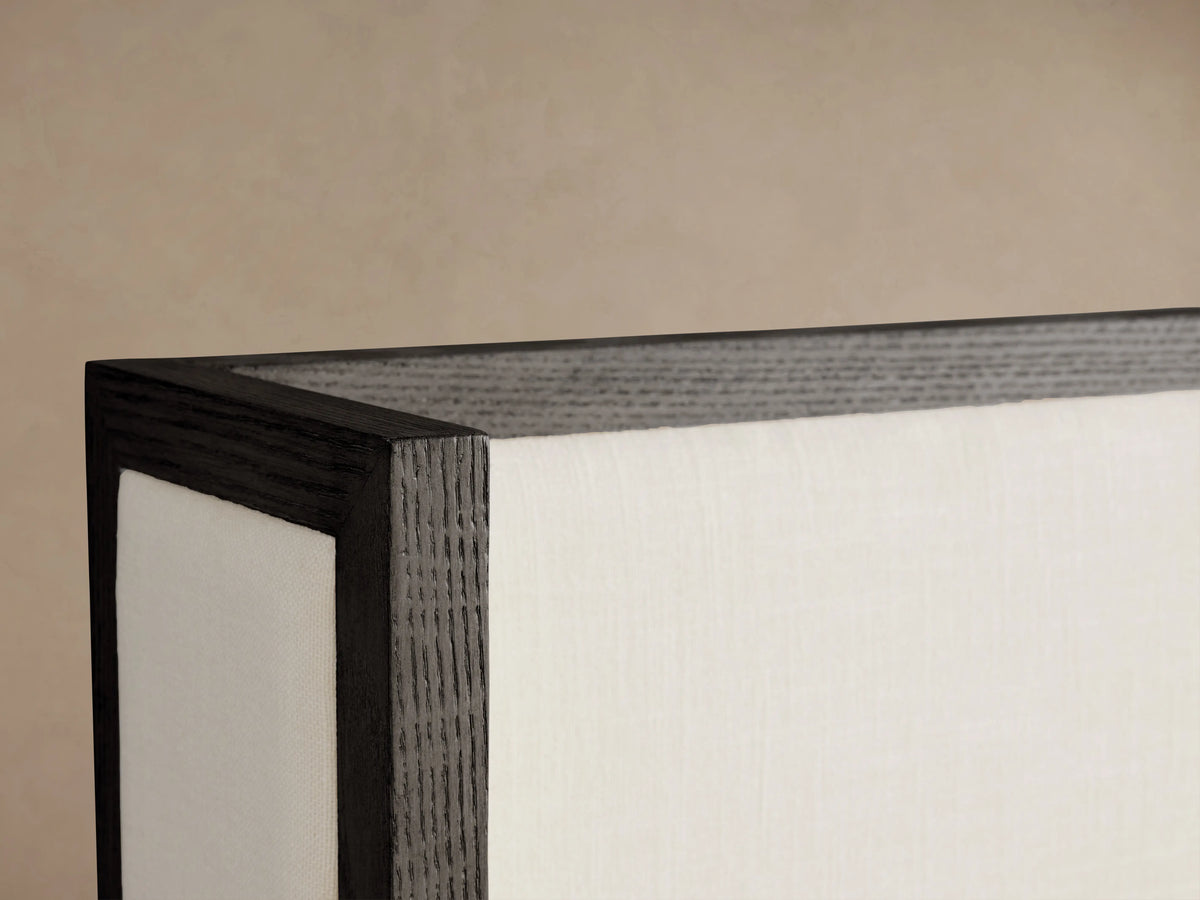 Darien Shelter Bed corner, showing dark oak veneer frame highlighted by upholstered white panel against a neutral background.