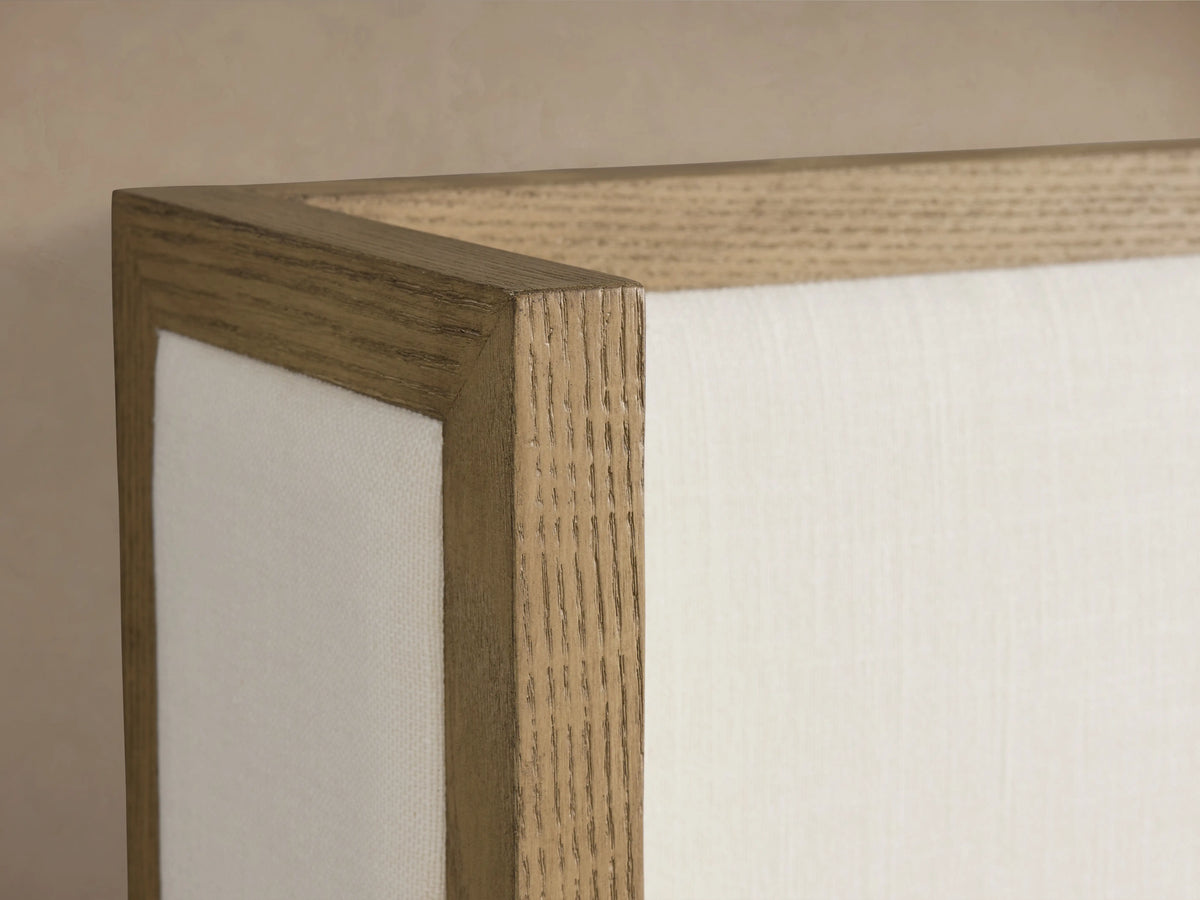 Darien Shelter Bed with low footboard, crafted from oak veneer with upholstered panels, features a white bedding set against a beige background.