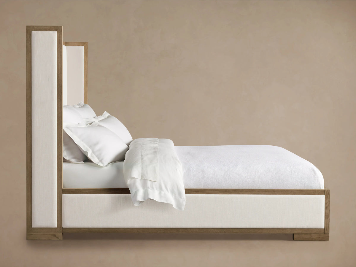 Darien Shelter Bed with Low Footboard, featuring oak frame with a hand-applied finish and white upholstered panels, in a room.