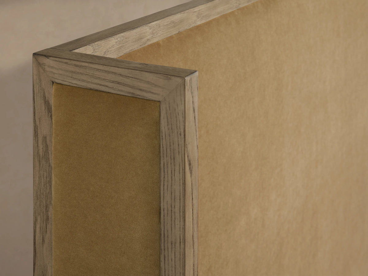 Close-up of the Darien Shelter Bed's corner, featuring oak veneer frame with hand-applied finish and upholstered panel in beige.