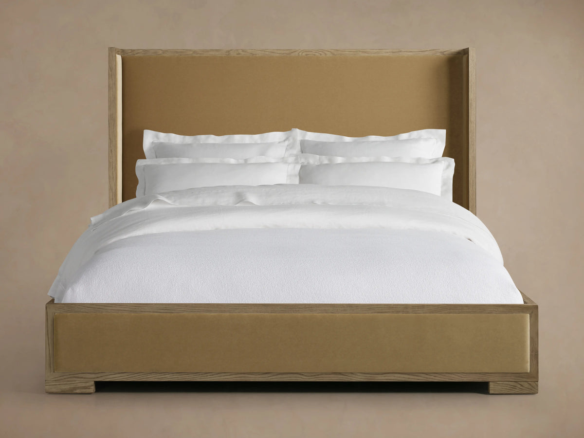 Darien Shelter Bed's low footboard corner in oak wood with hand-applied finish, featuring upholstered panel detail.