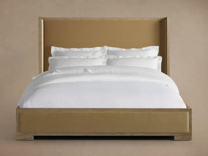 Darien Shelter Bed's low footboard corner in oak wood with hand-applied finish, featuring upholstered panel detail.