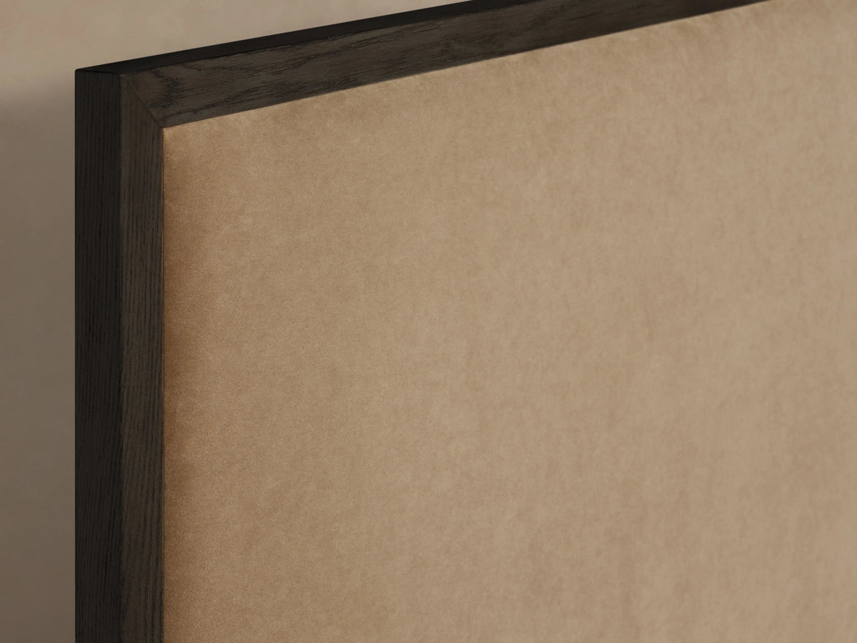 Edge of Darien Panel Bed in oak wood with a dark-brown frame and beige upholstered panel, close-up view.