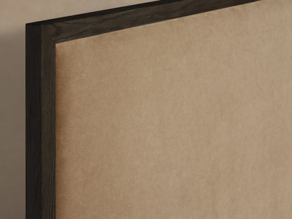 Edge of Darien Panel Bed in oak wood with a dark-brown frame and beige upholstered panel, close-up view.