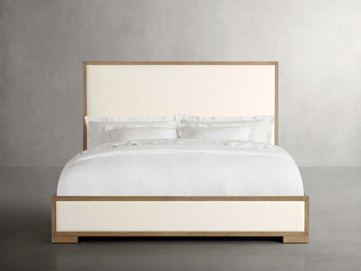 Darien Panel Bed with Low Footboard in oak wood and veneer, featuring upholstered panels and white bedding in a neutral setting.