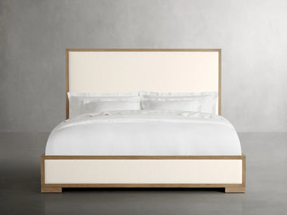 Darien Panel Bed with Low Footboard in oak wood and veneer, featuring upholstered panels and white bedding in a neutral setting.