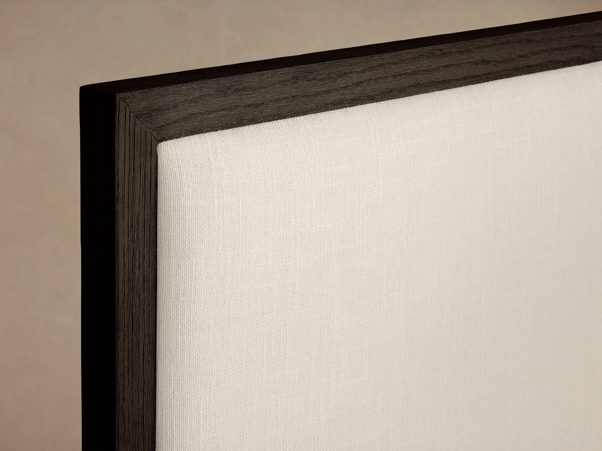 Dark oak wood frame with a hand-applied finish, featuring an off-white upholstered panel on the Darien Panel Bed.