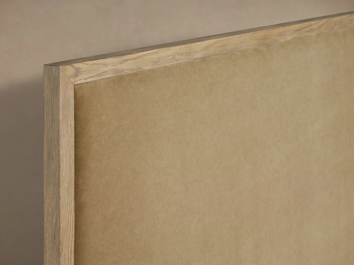 Darien Panel Bed headboard, close-up view, showcases oak frame with light brown upholstered panel, fine grain texture visible.