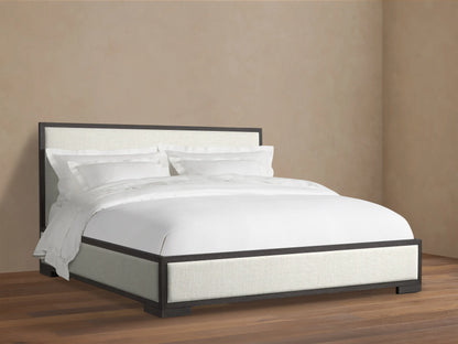 Darien Panel Bed with a dark wood frame and light upholstered panels, dressed with white bedding.