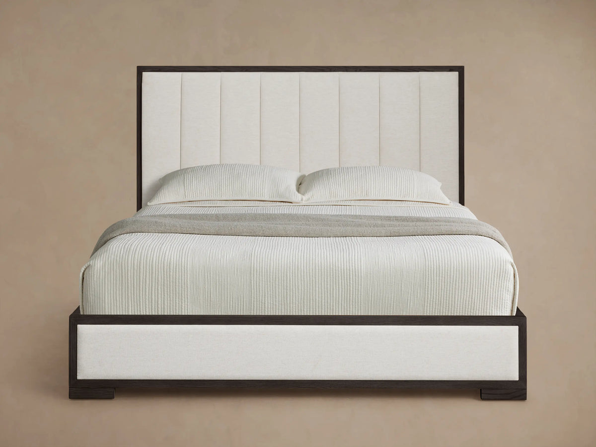 Darien Channel-Stitched Panel Bed with dark wood frame, cream channel-stitched headboard & upholstered sides. White bedding.
