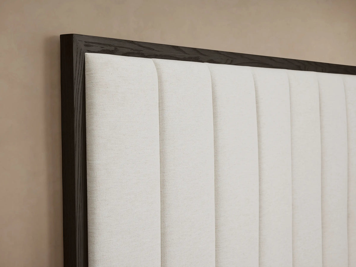 Darien Channel-Stitched Panel Bed with dark wood frame, cream channel-stitched headboard, white bedding, gray throw.