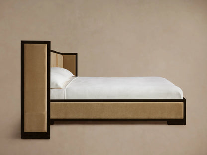 Corner of Darien Extended Box-Tufted Shelter Bed with dark oak frame and tan box-tufted and smooth upholstered panels.