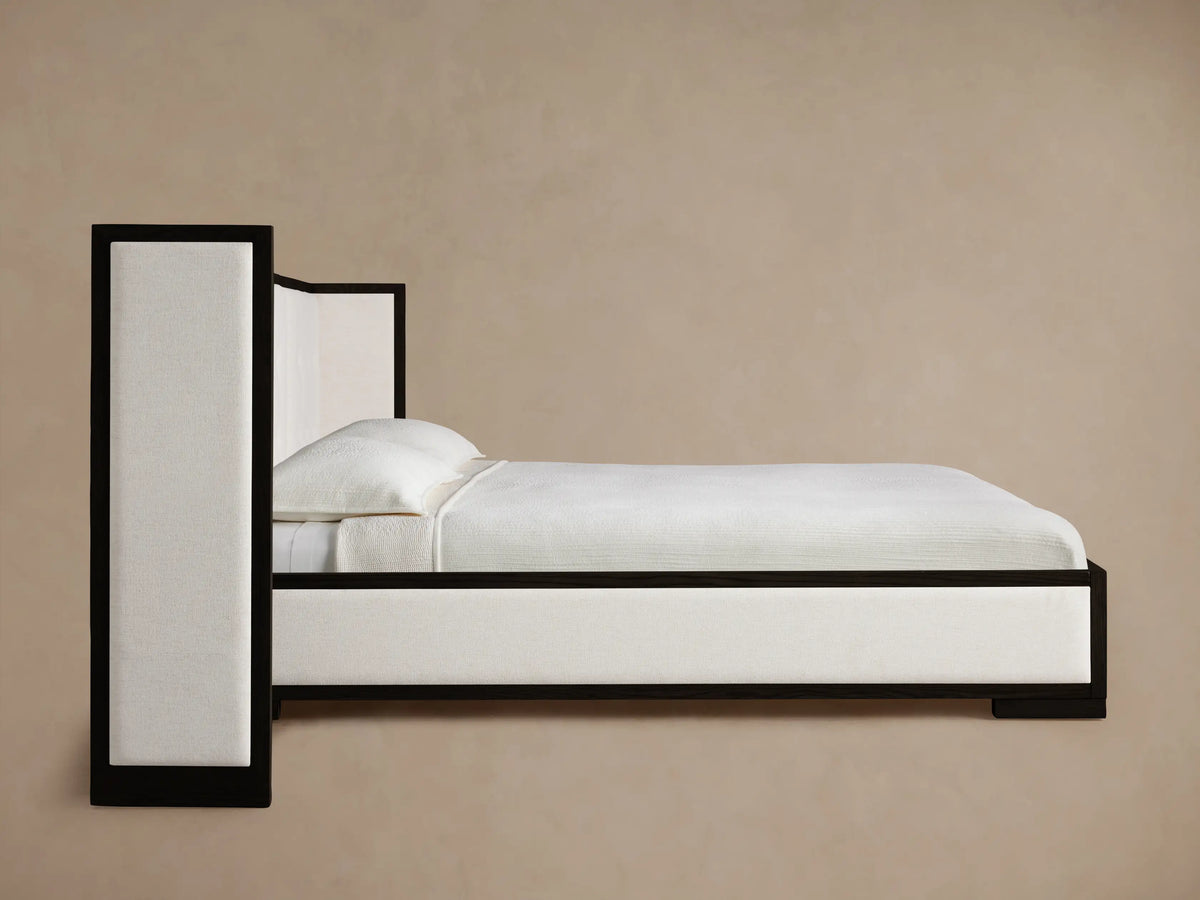 Close-up of Darien bed's dark oak frame and light cream box-tufted upholstered panel, showing texture and detail.