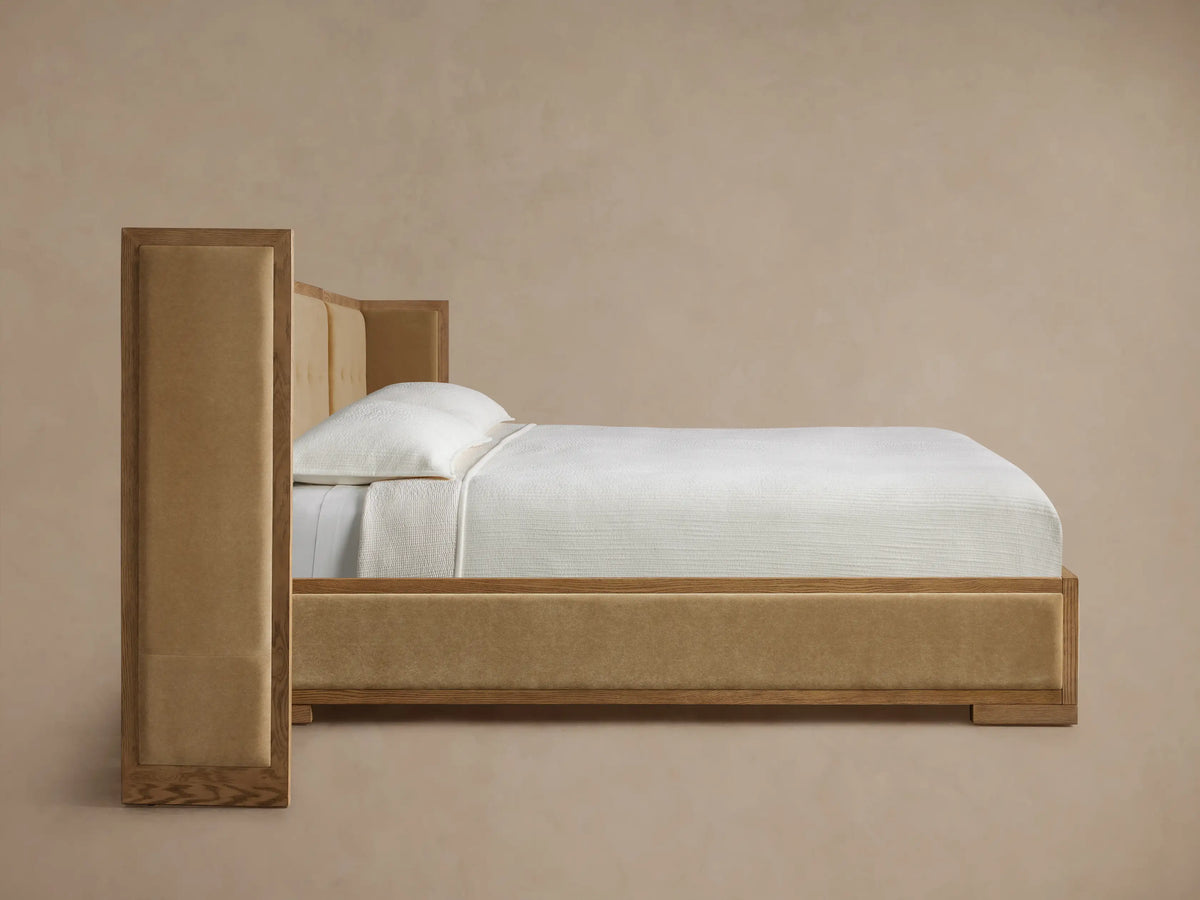 Close-up: Darien Extended Box-Tufted Shelter Bed headboard corner. Light oak frame, tan box-tufted upholstered fabric.