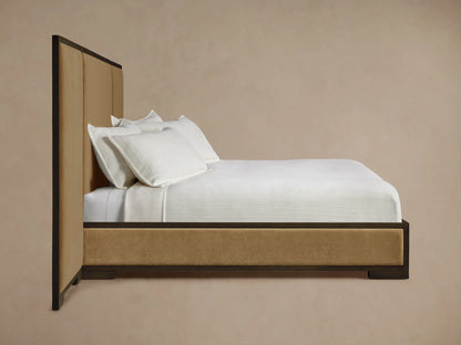 Darien Extended Panel Bed: Close-up of dark oak frame with wood grain surrounding a tan upholstered panel.