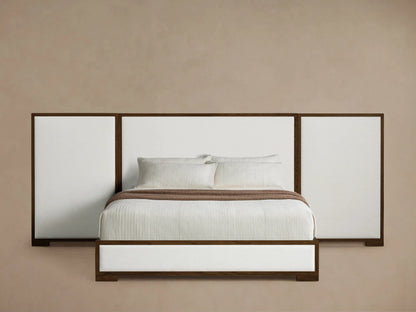 Front view of the Darien Extended Panel Bed with dark oak frame, white upholstered panels, white bedding, and a brown throw.