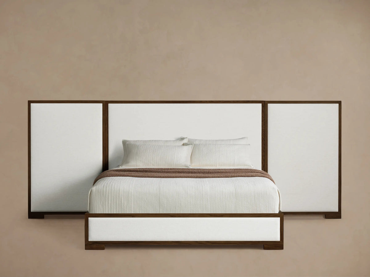 Front view of the Darien Extended Panel Bed with a dark brown oak frame and white upholstered panels. White bedding, brown throw.