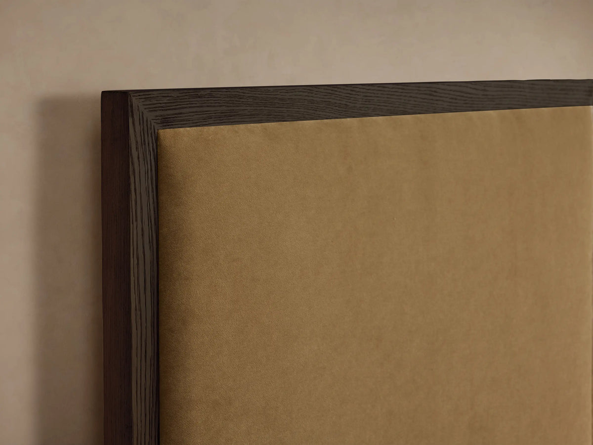 Wide Darien Extended Panel Bed: dark wood frame, tan upholstered panels, with white bedding against a neutral wall.