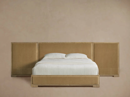 Darien Extended Panel Bed featuring light oak wood frame & gold-tan upholstered headboard/panels, white bedding, wood floor.