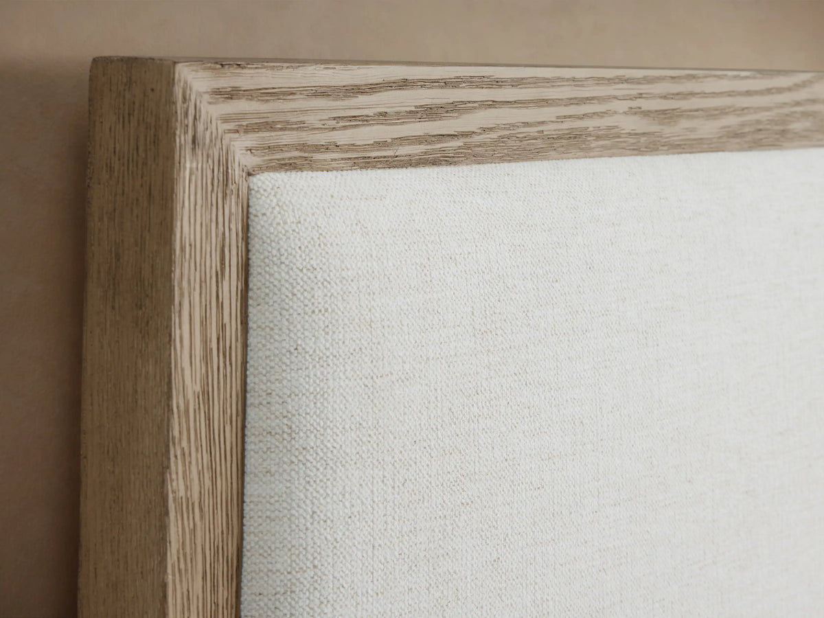 Darien Extended Panel Bed: light oak frame, white upholstered main headboard and two side panels, white bedding, brown throw.