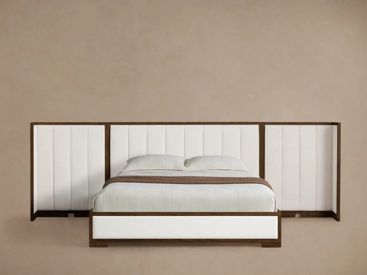 Front view of the Darien Extended Channel-Stitched Shelter Bed, featuring a dark wood frame, white channel-stitched upholstery, and white bedding with a brown throw.
