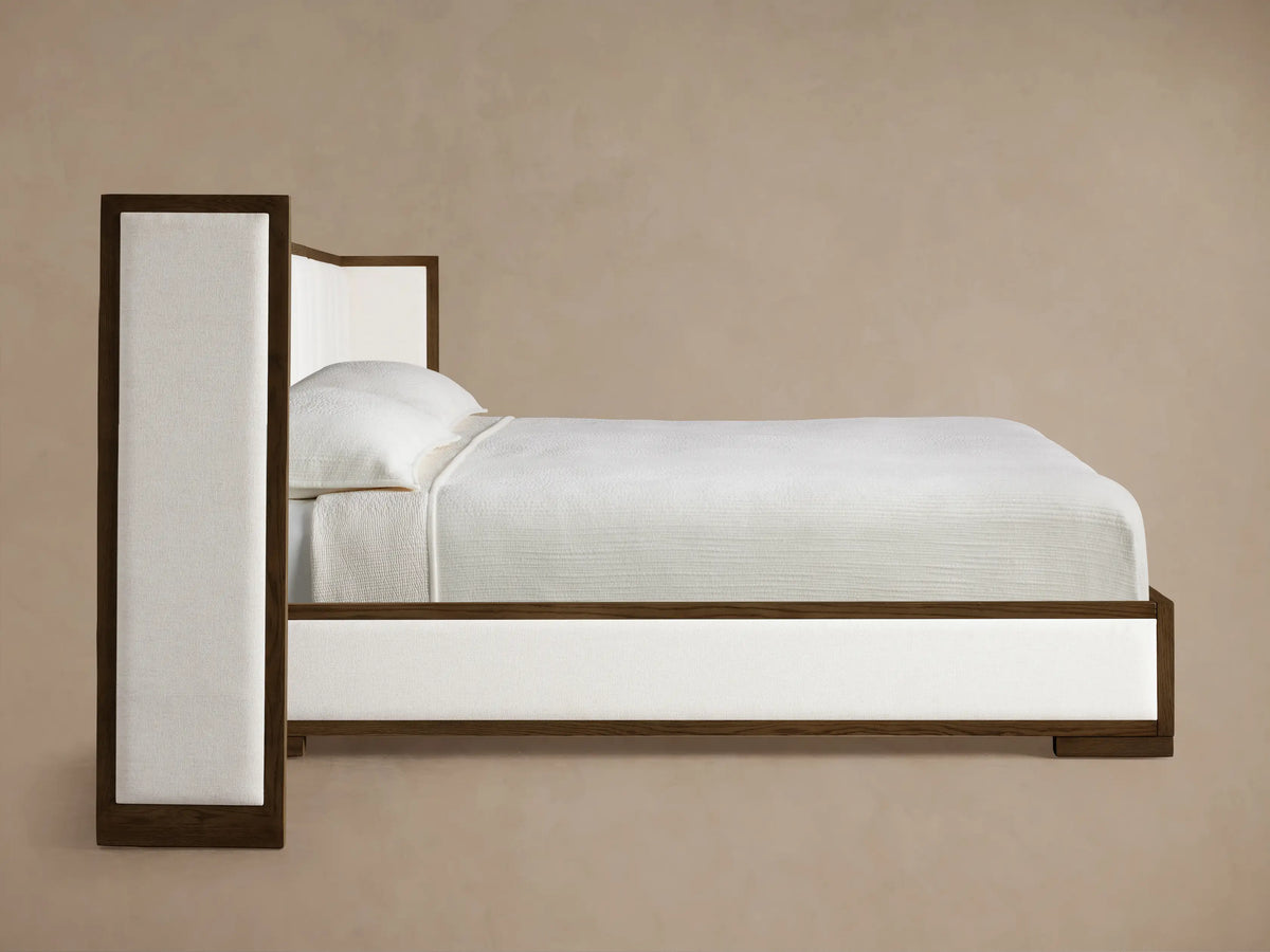 Close-up of the dark oak wood frame and cream channel-stitched upholstered panels of the Darien Extended Channel-Stitched Shelter Bed.