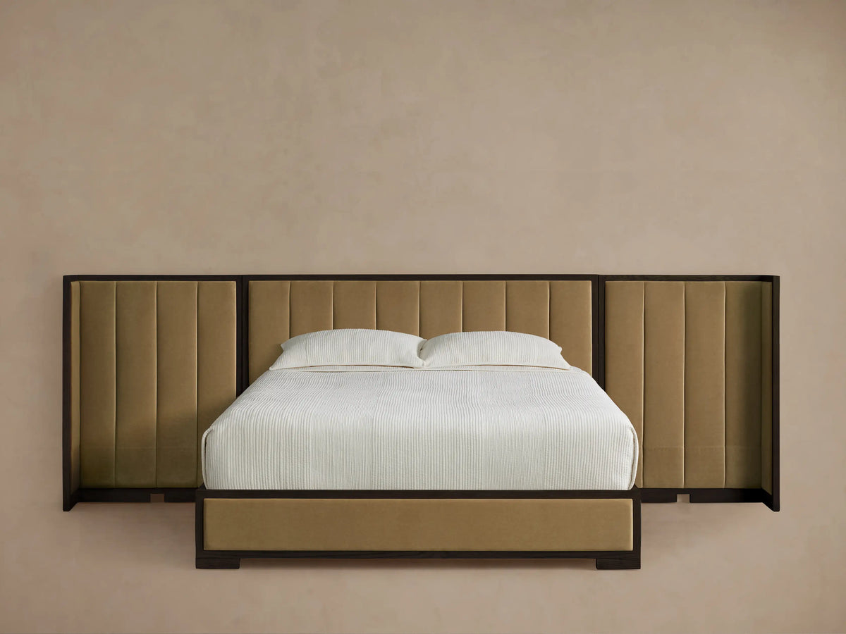 Darien Extended Channel-Stitched Shelter Bed with beige upholstered panels, dark wood frame, white bedding, wood floor.
