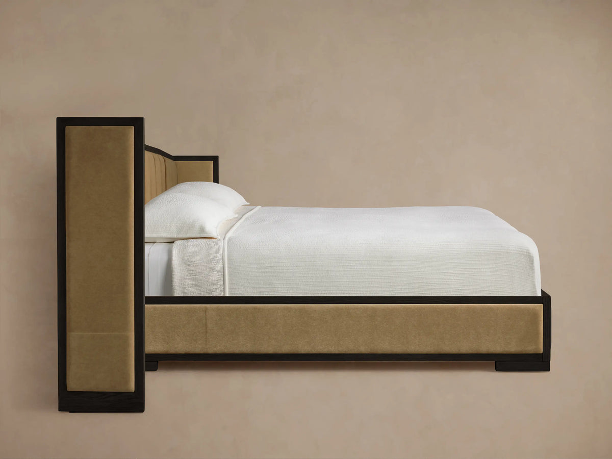 Close-up of Darien Extended Channel-Stitched Shelter Bed with dark wood frame and beige channel-stitched upholstery at a corner.