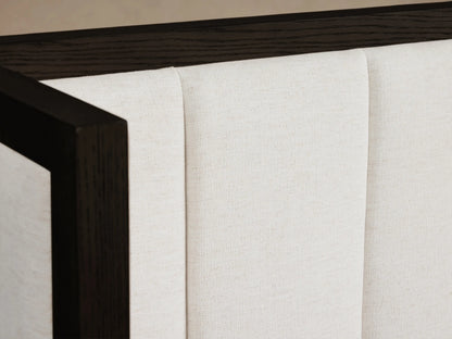 Darien Extended Channel-Stitched Shelter Bed. White channel-stitched upholstery, dark wood frame, extended headboard, light bedding.