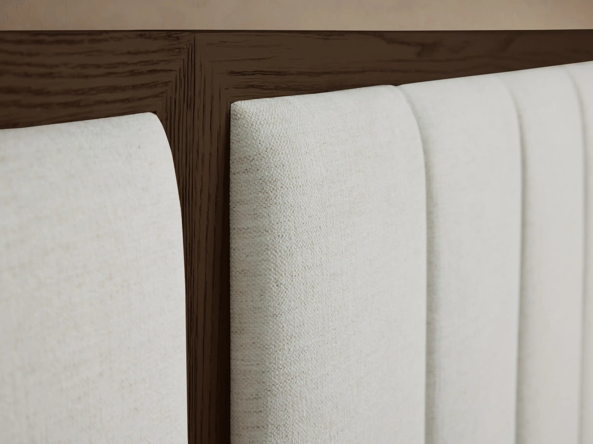 Close-up of the Darien Extended Channel-Stitched Panel Bed headboard with light beige upholstered channels and dark brown oak wood frame.