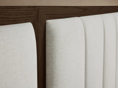 Close-up of the Darien Extended Channel-Stitched Panel Bed headboard with light beige upholstered channels and dark brown oak wood frame.