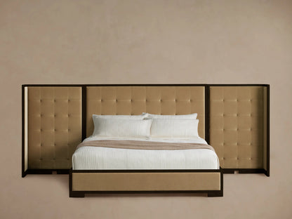 Darien Extended Box-Tufted Shelter Bed in tan upholstery with dark wood frame, white bedding & brown throw on wood floor.
