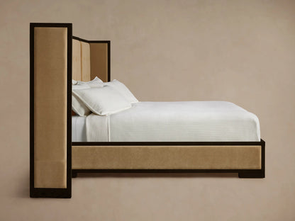 Corner of Darien Extended Box-Tufted Shelter Bed, dark oak frame with beige box-tufted upholstered panels.