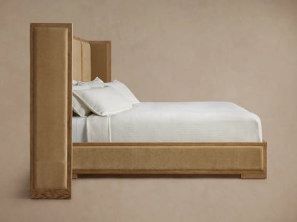 Close-up of a luxurious tan tufted headboard with a light wood frame and a dark brown fabric side panel.