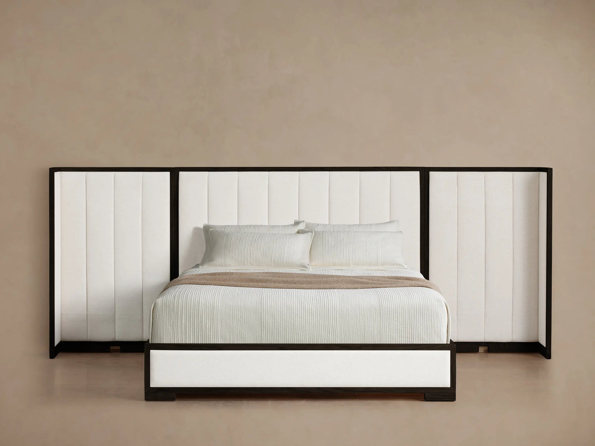 Darien Extended Channel-Stitched Shelter Bed, featuring a white upholstered headboard & side panels with dark wood frame, angled view.