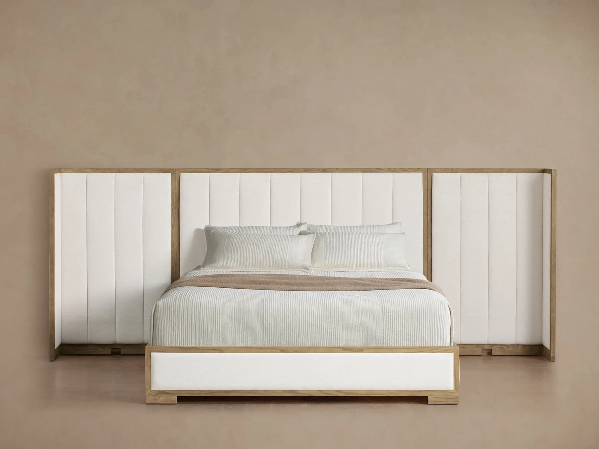Darien Extended Channel-Stitched Shelter Bed with tall white upholstered headboard, light wood frame, white bedding, and throw.