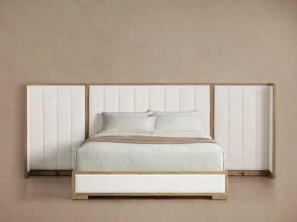 Darien Extended Channel-Stitched Shelter Bed with tall white upholstered headboard, light wood frame, white bedding, and throw.
