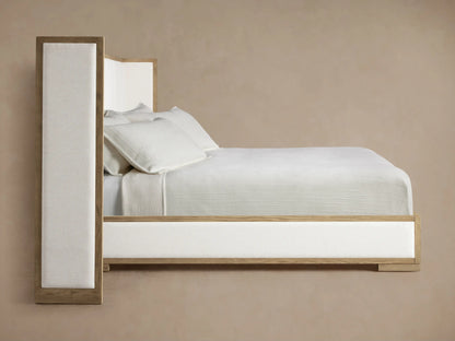 Close-up of Darien Extended Shelter Bed's light oak frame and cream channel-stitched upholstered panel, viewed from an angle.